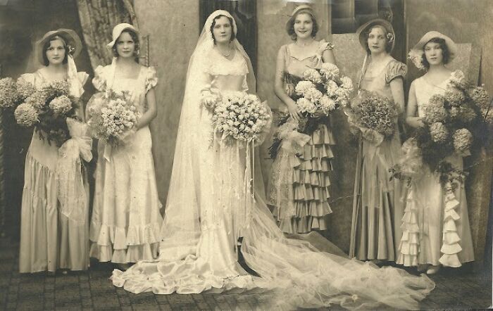 Rare vintage wedding photo showing bride and bridesmaids in elegant dresses from 50-100 years ago.