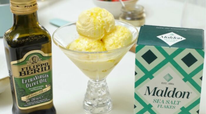 Weird food combo featuring olive oil and sea salt with ice cream in a glass dish.