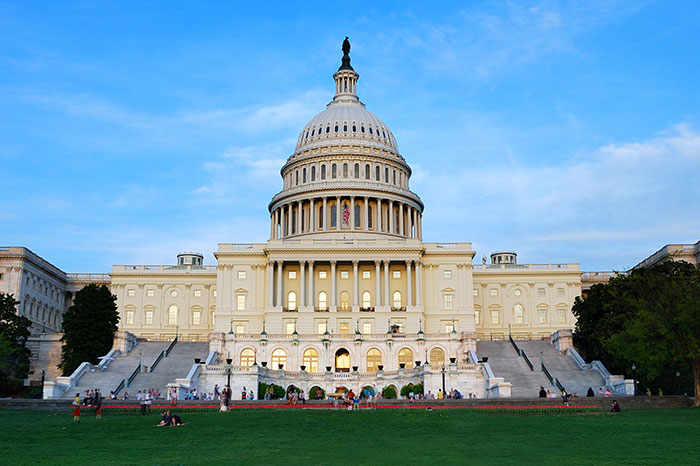 U.S. Capitol building with people on the lawn, a symbol of America.