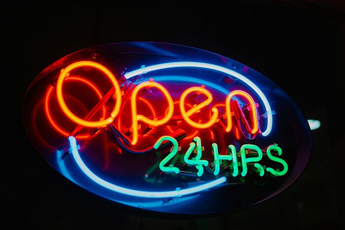 Neon "Open 24hrs" sign glowing in the dark, representing things gradually disappeared.