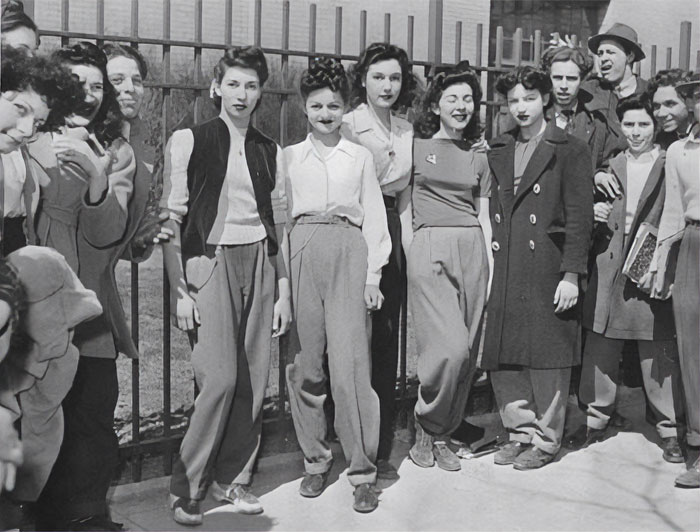 Group of young people in 1940s American fashion standing outdoors, showcasing everyday life in the past.