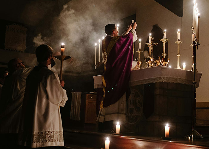 Priest in a ritual with candles lit, representing a path for the brightest kids achieving spiritual roles.