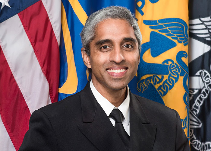 Smiling man in a suit with flags, representing bright kids' achievements.