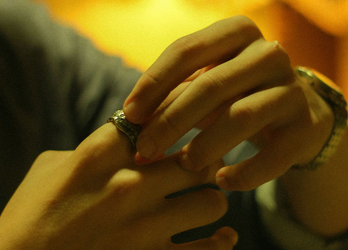 Hands nervously playing with a ring, symbolizing uncertainty and suspicion.
