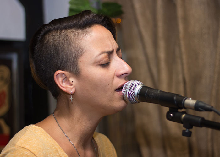 Person with short hair singing into a microphone, illustrating wild audition moments.
