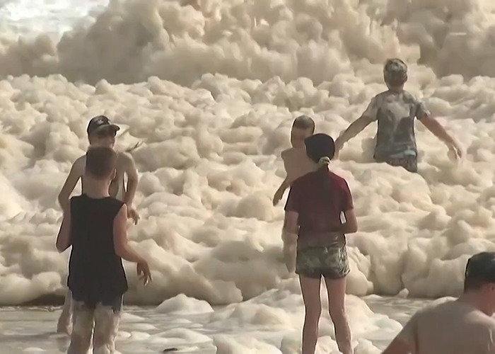 People playing in sewage-filled sea foam, sparking viral outrage. People playing in sewage-filled sea foam, sparking viral outrage.