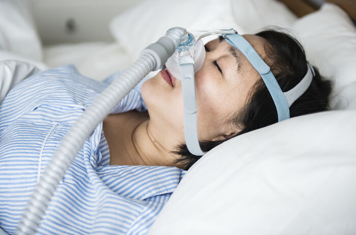 Person sleeping with CPAP mask, depicting impact on life quality under $500.
