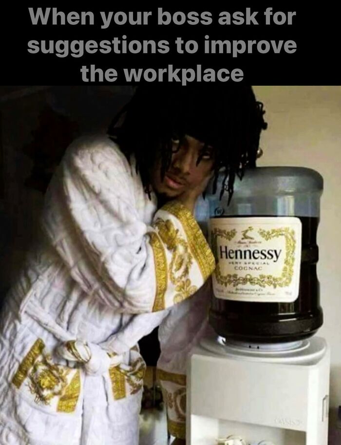 Man in robe humorously pretending to replace water cooler with Hennessy, a funny work meme.