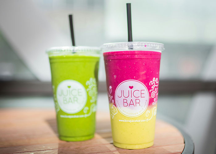 Two colorful smoothies from a juice bar on a wooden table, linked to worst diets theme.