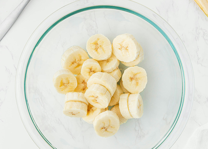 Sliced bananas in a clear bowl illustrating a diet theme.