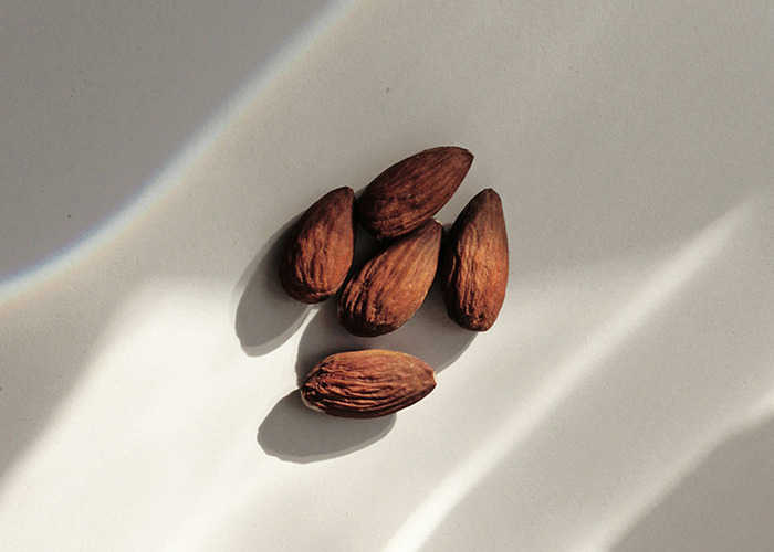 Almonds casting shadows on a surface, highlighting elements of worst diets.