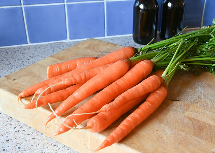 Carrots on a wooden board, possibly part of a diet plan.