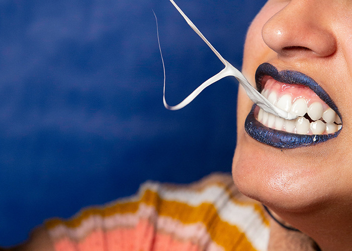 Woman with blue lipstick pulling gum from teeth, illustrating worst diets concept.