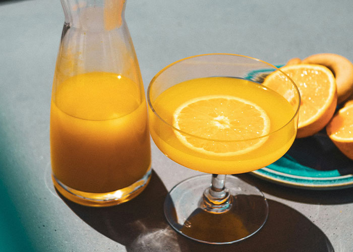 Orange juice and slices on a table, highlighting worst diets with a focus on liquid-based diet trends.