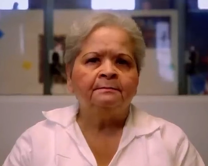 Elderly woman in a white shirt, related to Selena's assassination parole news.