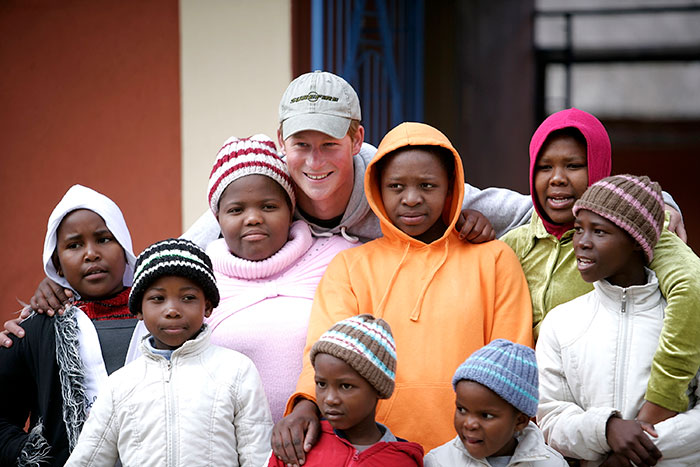 A group of people, including a man in a cap, posing together outside.