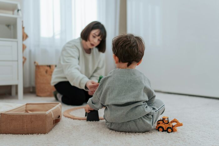 Woman and child playing with toys indoors, illustrating a work-life balance moment.