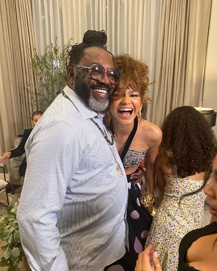 Zendaya laughing with her father at a family gathering, embracing joyful moments together.