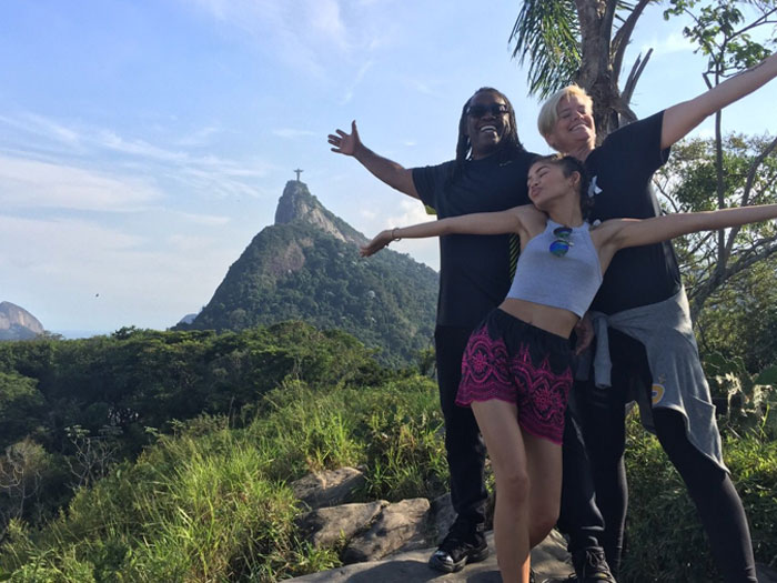 Zendaya with family enjoying a scenic view near the Christ the Redeemer statue, with arms spread wide in joy.