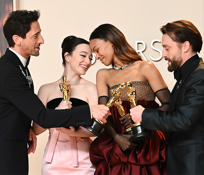 Group of actors celebrating with Oscars at the 2025 awards ceremony, smiling and holding their trophies joyfully.