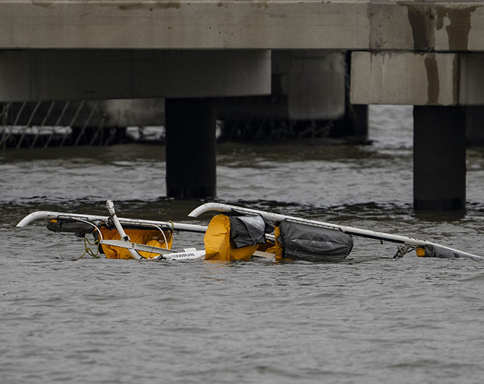 Wreckage of NYC helicopter in water under bridge following fatal crash.