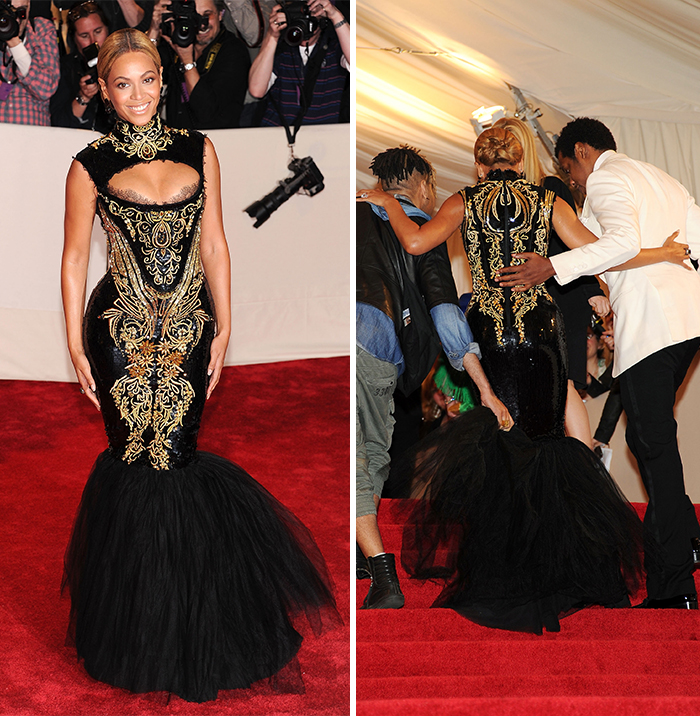 Celebrity in ornate black and gold dress on red carpet, showcasing fashion sacrifices amidst photographers.