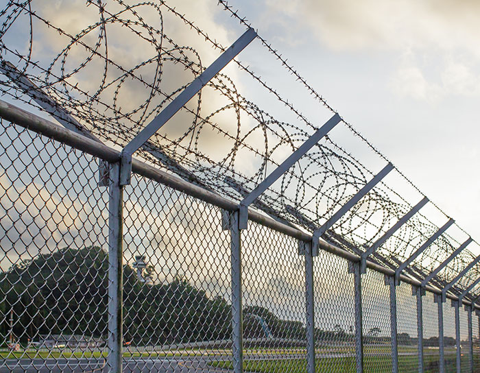 Barbed wire fence at sunset, symbolizing parental conflict and disagreement over beliefs.