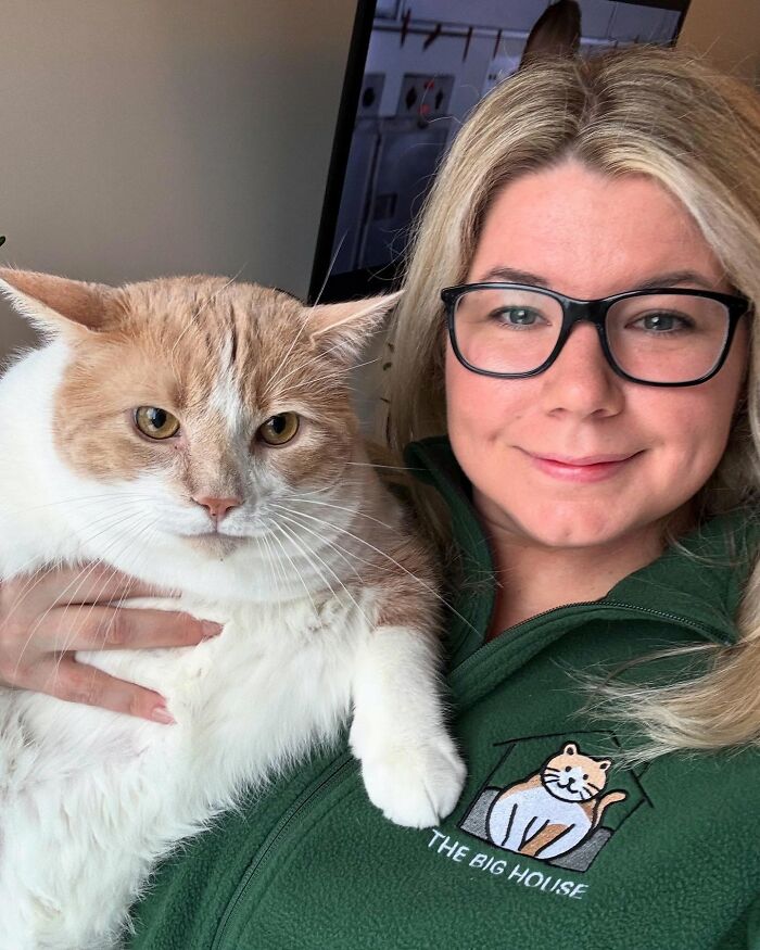 Woman holding a cat that used to be overweight, both appearing content and healthy. Woman holding a cat that used to be overweight, both appearing content and healthy.