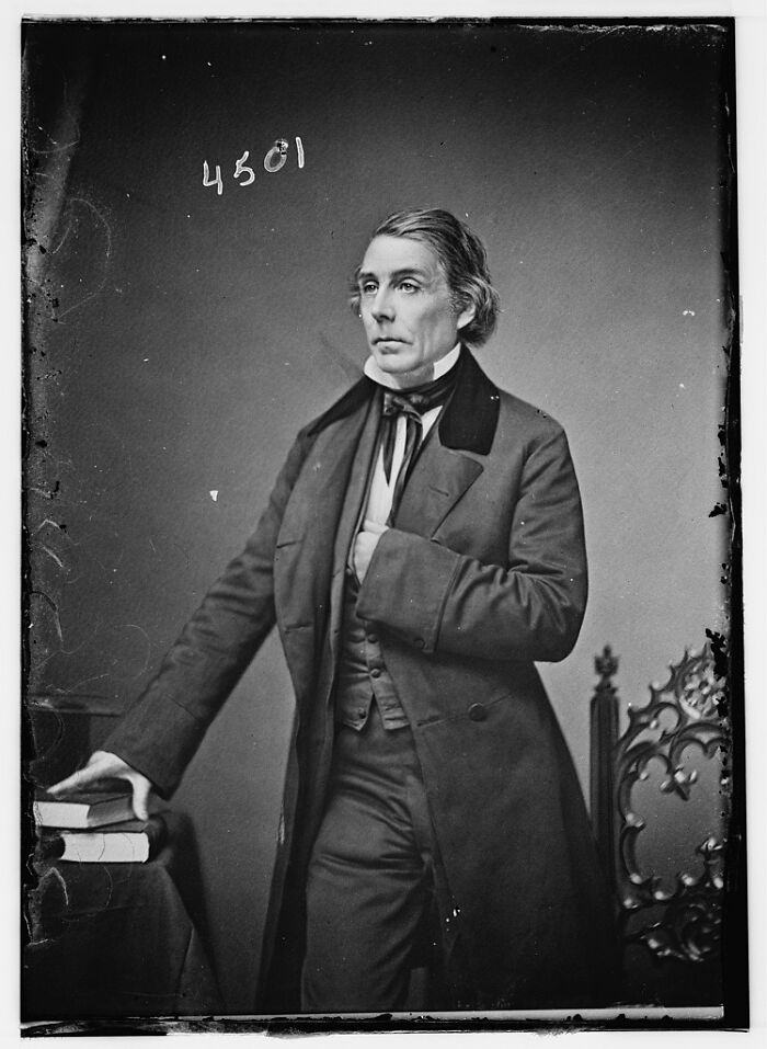 Vintage black and white portrait of a man in formal attire, rare photograph rescued from glass negatives.