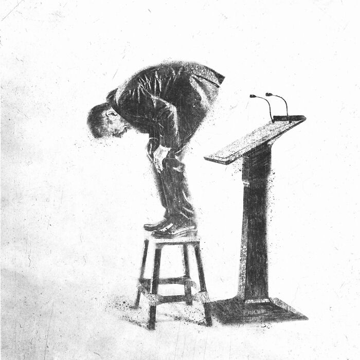 Person in suit bent over on a stool beside a podium, representing modern madness in art.