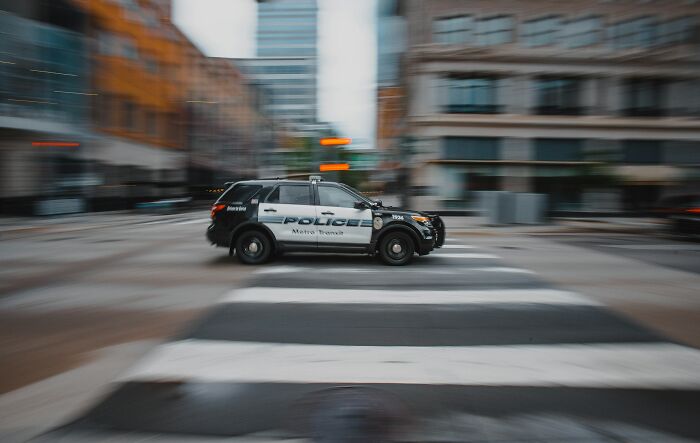Police SUV speeding through an urban street, showcasing one of the things that look awesome in movies but are terrible in real life.