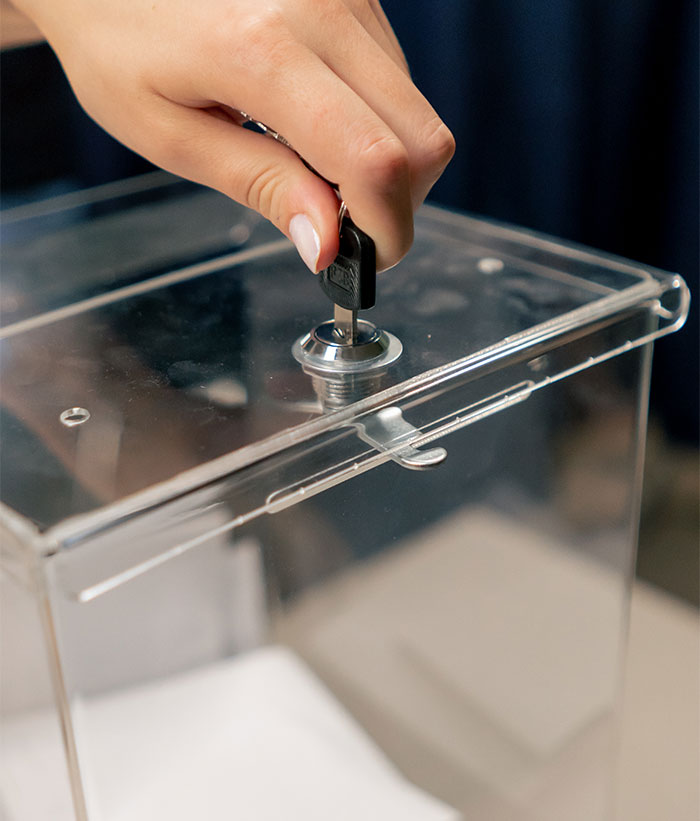 Hand locking a clear fridge lockbox to secure cheese from roommates.