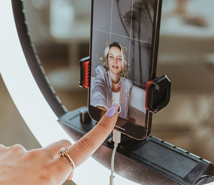 Fitness influencer recording a video on smartphone with ring light, fans reacting to weight loss truth reveal. Fitness influencer recording a video on smartphone with ring light, fans reacting to weight loss truth reveal.