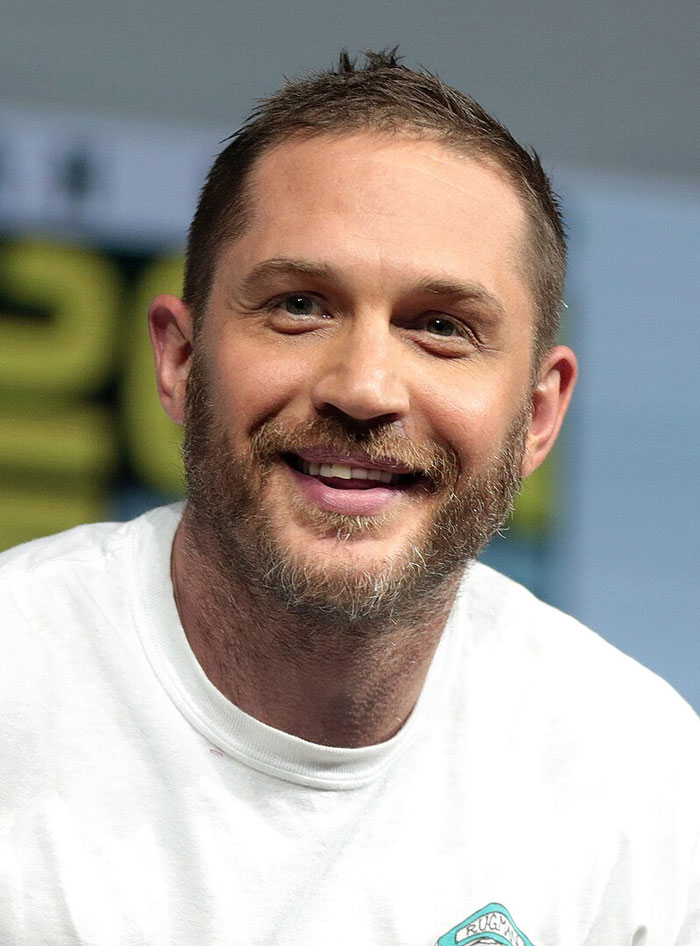 Smiling man with a beard in a white shirt at an event, embodying wholesome qualities beloved by fans.