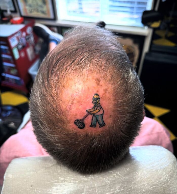 Homer Simpson tattoo on a bald head, showcasing a unique Simpsons tattoo design.
