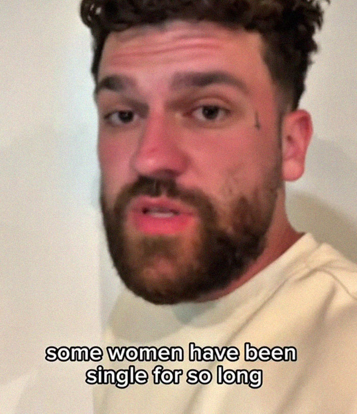 Man with beard and short curly hair explaining dating perpetually single women in a casual setting with text overlay.