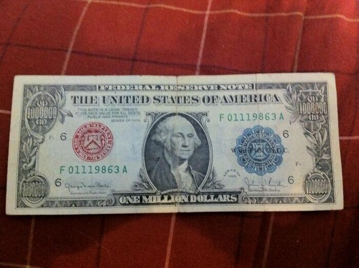 Fake one million dollar bill placed on a red checkered fabric resembling a ridiculous relationship argument prop.