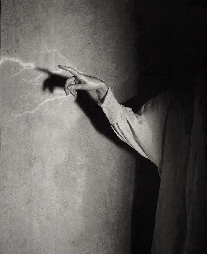 A mysterious hand casting a shadow on a textured wall, embodying dark escapism photography.