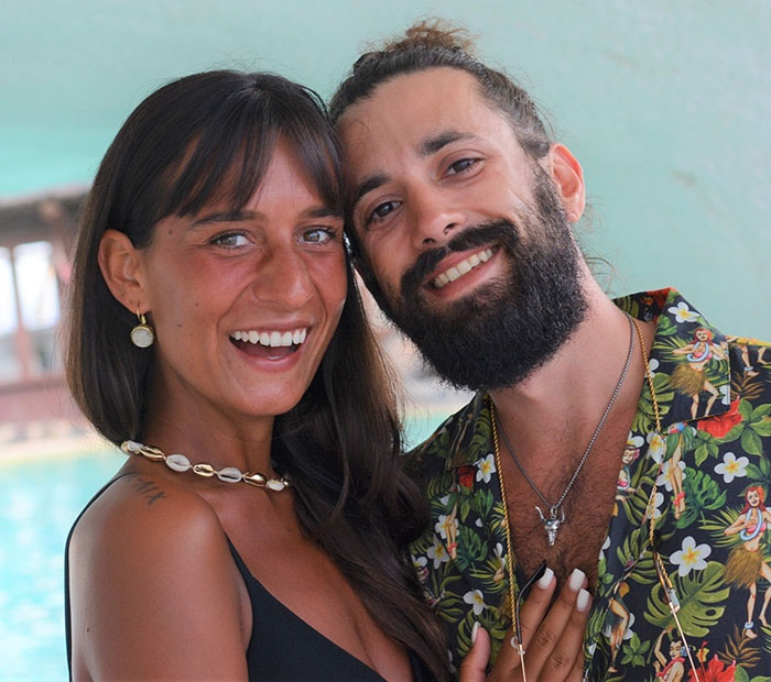 A smiling couple posing together, capturing a moment while traveling, related to mysterious illness awareness.