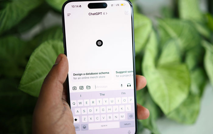 Hand holding a smartphone displaying ChatGPT interface, related to submit SEO deliverables and work hacks.