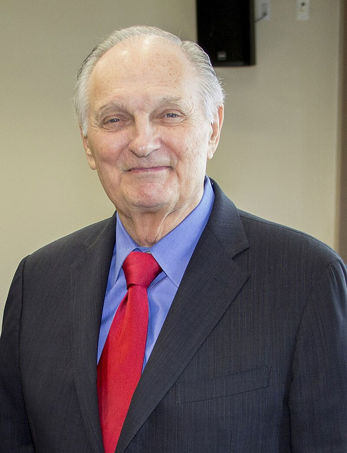 Man in a suit with a red tie smiling warmly, highlighting wholesome qualities of beloved stars.