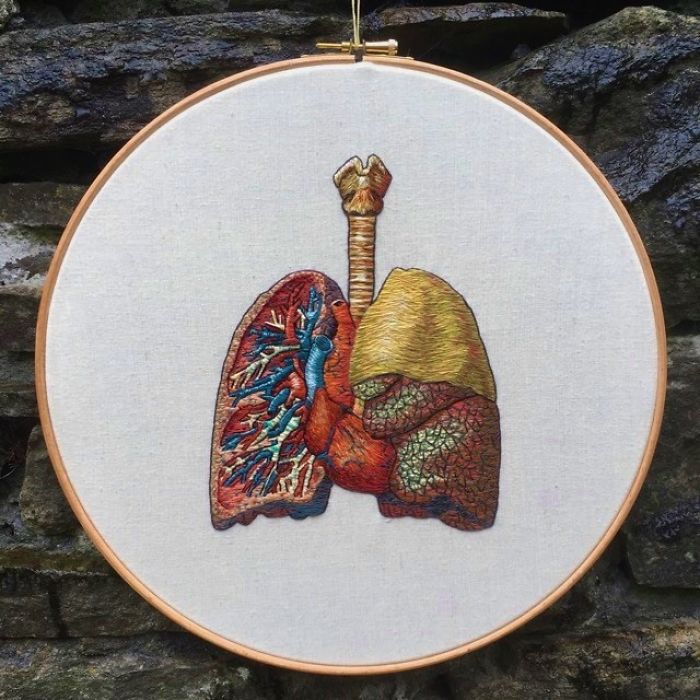 Embroidery work of detailed human lungs in a wooden hoop, showcasing intricate artistic techniques.