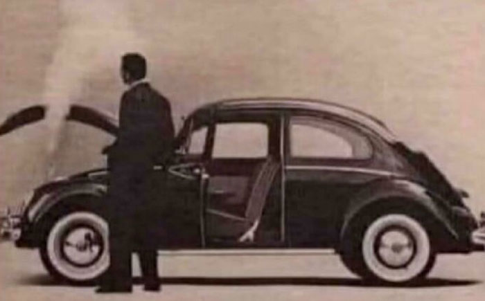 Man next to vintage car with open doors and hood, evoking nostalgia and feeling old.