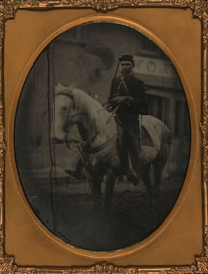African American soldier on horseback in historical uniform, showcasing strength and resilience over a century ago.