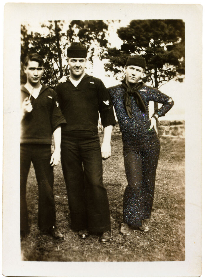 Three sailors in uniform pose together outdoors, capturing a moment of camaraderie and connection, embodying love without boundaries.