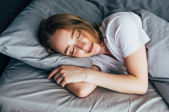 A woman peacefully sleeping in bed, illustrating how everyday things like sleep can be unexpectedly dangerous.
