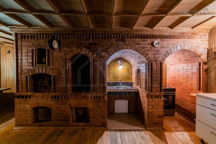 Unique brick interior kitchen with wood ceiling and floors, showcasing wild real estate properties for sale.