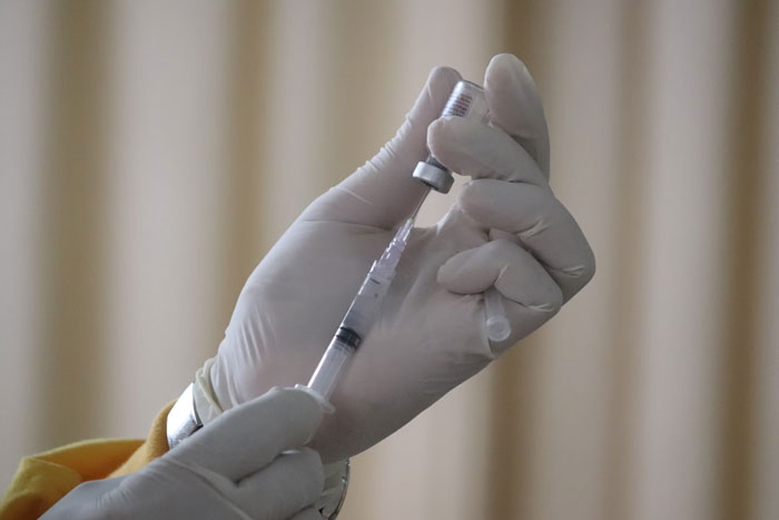 Gloved hands holding a syringe, highlighting the importance of updated vaccines. Gloved hands holding a syringe, highlighting the importance of updated vaccines.