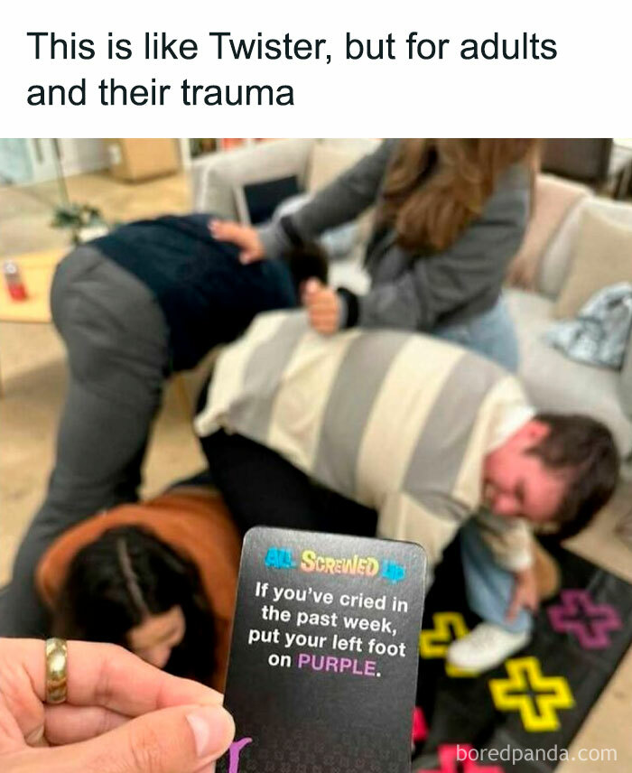Adults playing a Twister-like game with humorous trauma-related card directive, evoking side-splitting meme laughs.