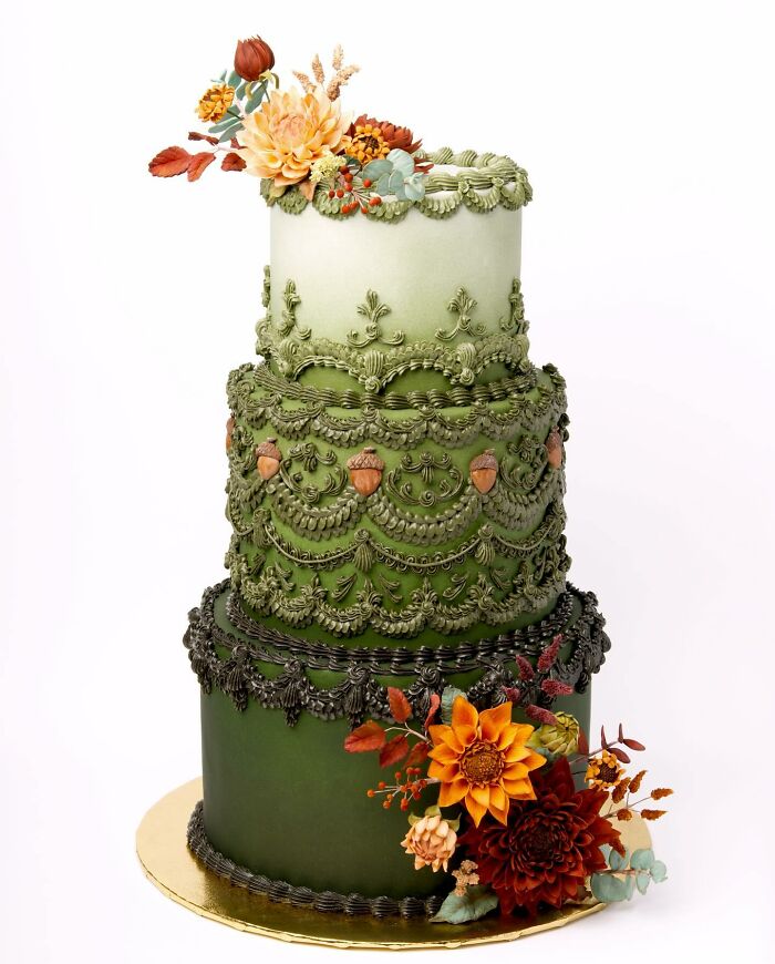 Vegan cake with intricate green icing, acorn details, and vibrant floral decorations.